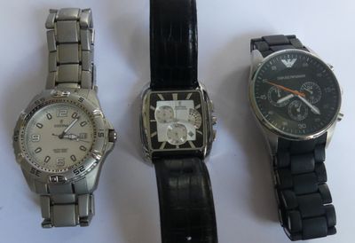 three watches are sitting next to each other on a white surface