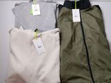 trois paires de vêtements pour homme posées sur une table blanche