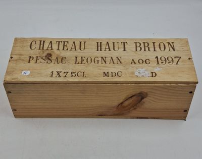 une vieille caisse en bois sur laquelle est accrochée une pancarte indiquant « Château Haut-Brion »