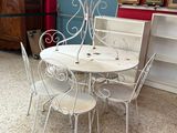 une table et des chaises blanches dans une pièce aux murs rouges