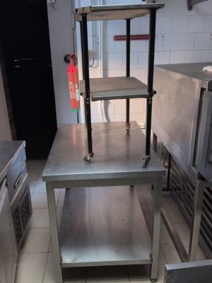 une table en acier inoxydable avec une étagère, dans une cuisine