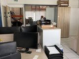 un bureau avec un écran d'ordinateur et une chaise dans une pièce