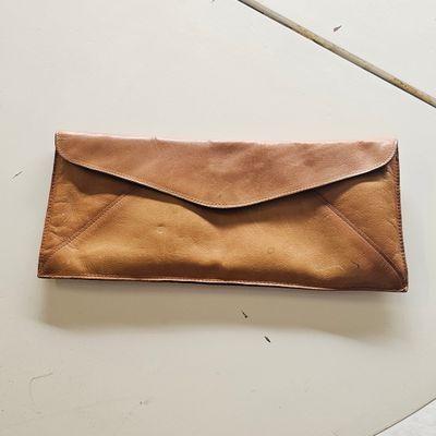 an image of a brown leather envelope sitting on top of a white table