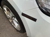 a close up of a white car with a clock on the front of it