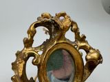 a gold picture frame with a picture of a woman in it