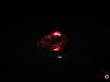 a close up of a red diamond on a black surface