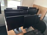 four computer monitors sitting on a desk in a room