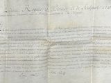 an old document with writing on it sitting on a table