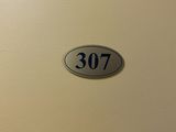 une photo d'une porte sur laquelle figure le numéro 3077