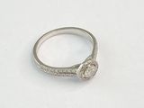 une image d'une bague en diamant sur une surface blanche