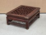 a small wooden table with a lattice design on it