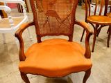 an orange chair that is sitting in the middle of a room
