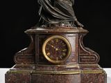 a statue of a woman holding a clock on a table