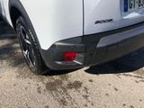 the rear end of a white suv parked in a parking lot