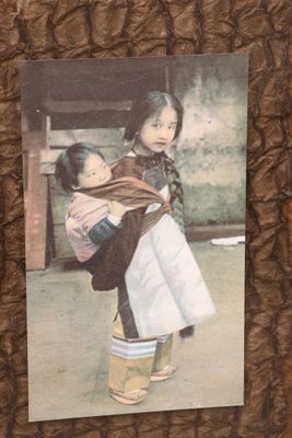 a picture of a young girl holding a baby in her arms