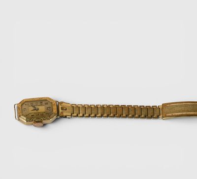 une montre en or avec un bracelet en métal et un fermoir en or