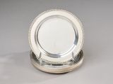 a silver plate with a beaded edge sitting on a table