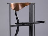 un gros plan d'une chaise avec une assise en bois et un piètement en métal