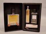 two bottles of perfume in a black box on a white surface