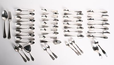 un grand nombre de cuillères et de fourchettes disposées sur la table
