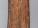 an old wooden plaque with a cross on it on a gray surface
