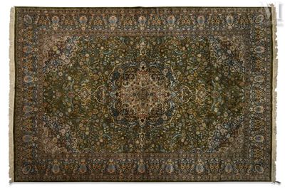 an antique persian rug with a medallion design on a green ground
