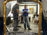 un homme et une femme debout devant un miroir