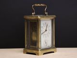 a small clock sitting on a table with a black background