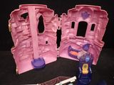a pink toy castle with a pink door and a purple door