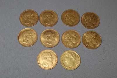 six types différents de pièces d'or posées sur une surface bleue