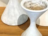 two white vases sitting on a table next to each other