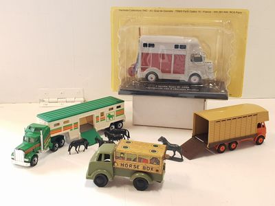three toy trucks and a truck in a box