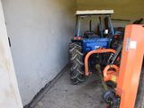 a tractor and a fork in the garage of a house