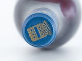 a close up of a bottle of wine on a white surface