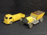 two toy trucks sitting next to each other on a black surface