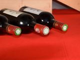 several bottles of wine are lined up on a red table cloth