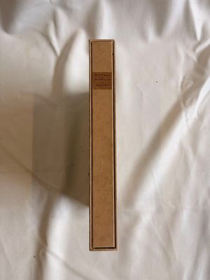 une boîte marron posée sur un lit recouvert d'un drap blanc