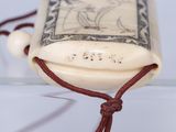 a small piece of ivory with a red string around it