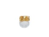 gros plan d'une bague en or sur une surface blanche