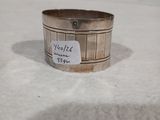 une vieille bague en argent munie d'une étiquette, posée sur une surface blanche