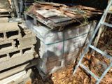 a pile of wood sitting on the ground next to a ladder