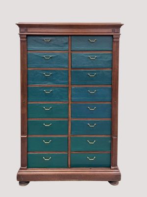 une commode en bois avec des tiroirs verts et des poignées en laiton