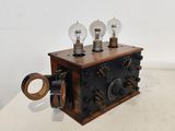 une petite boîte en bois surmontée de trois ampoules