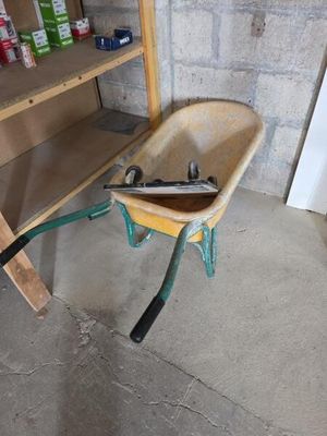 une brouette contenant des outils, dans un garage