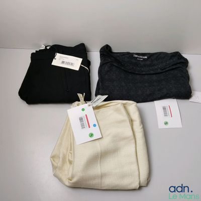 trois paires de pantalons pour homme posées les unes à côté des autres sur une table