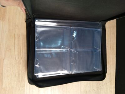 une personne tenant une mallette noire avec des séparateurs en plastique transparent
