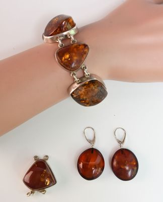 bracelet and earring set with amber stones on a mannequin hand