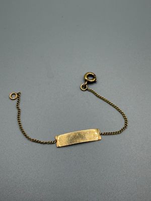 un bracelet plaqué or auquel est attachée une chaîne