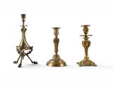 three brass candlesticks are sitting next to each other on a white surface