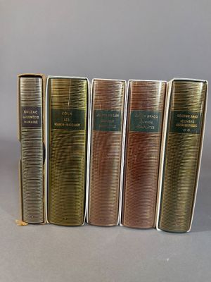 five books are lined up in a row on a gray surface